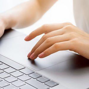 hands type on laptop keyboard.