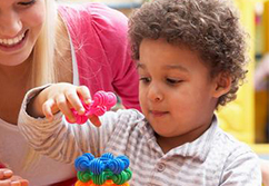 young child stacks colorful blocks.