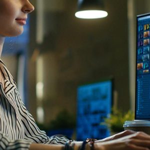 student edits video on 2 computer screens.